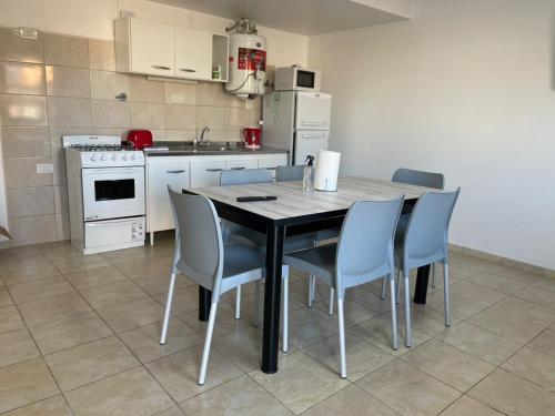 Una cocina con una mesa y sillas en una cocina. en Departamentos Alberdi 1, en San Rafael