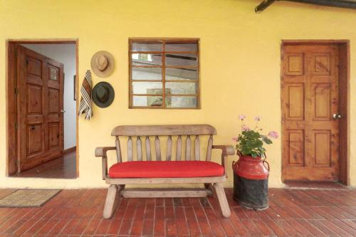a bench with a red cushion sitting in a room at Cabaña de Hacienda Nebraska in Zipacón