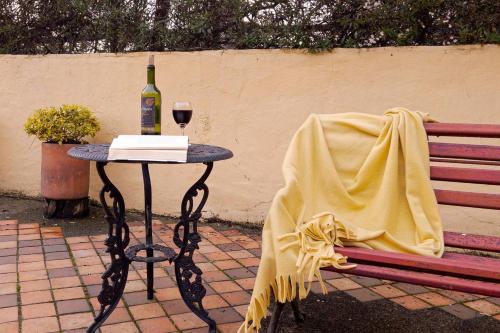 a table with a bottle of wine and a glass at Cabaña de Hacienda Nebraska in Zipacón
