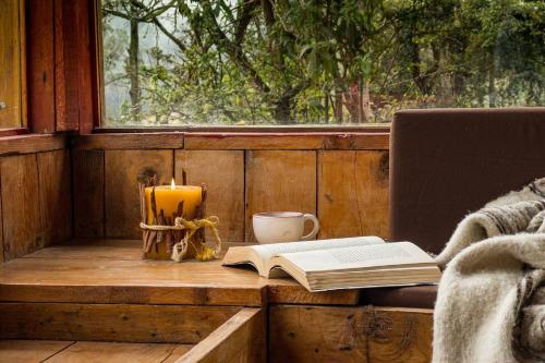 a table with a book and a candle and a candle at Cabaña de Hacienda Nebraska in Zipacón