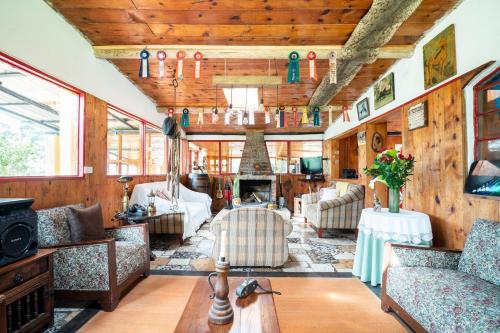 a living room with couches and a fireplace at Cabaña de Hacienda Nebraska in Zipacón