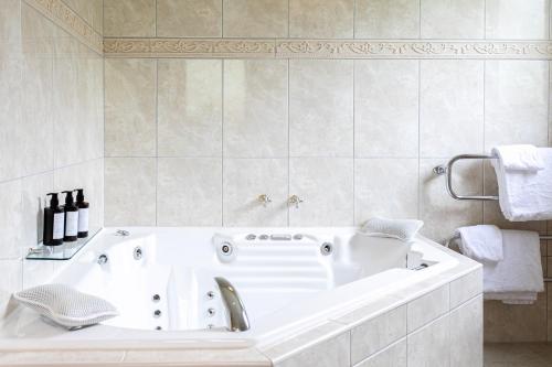 a white bath tub in a white bathroom at Chalet Eiger in Taupo