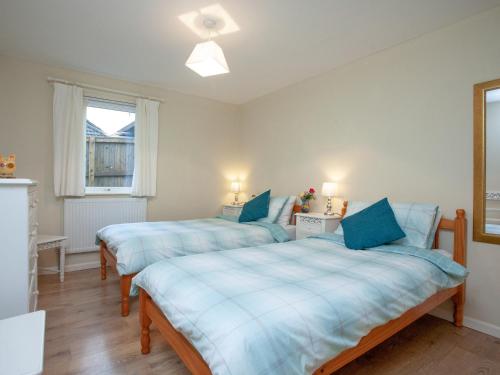 Washfield的住宿－查萊特埃特蒂博托普度假屋，一间卧室配有两张蓝色床单