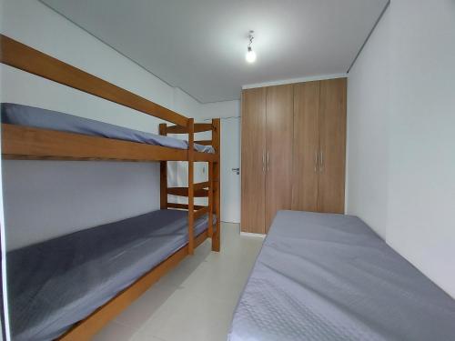 1 Schlafzimmer mit 2 Etagenbetten und einem Schrank in der Unterkunft Apartamento perto da praia no Indaiá in Bertioga