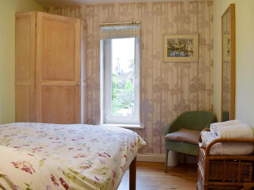 um quarto com uma cama, uma janela e uma cadeira em The Writing Room em Barford