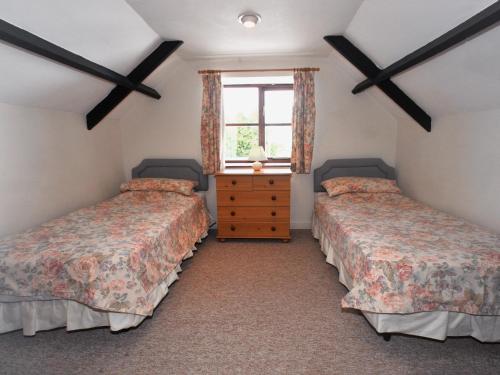 two twin beds in a room with a window at Barrowmead Cottage - E2377 in Banwell
