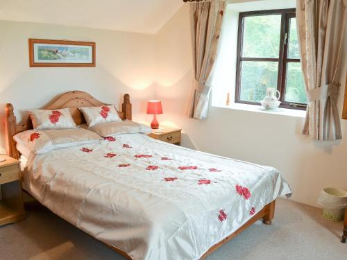 a bedroom with a large bed with flowers on it at Burnoon Barn in Cury