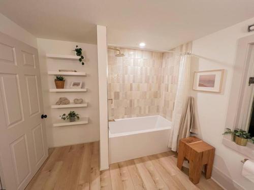 een witte badkamer met een bad en een douche bij Beach House in Niagara in Wainfleet