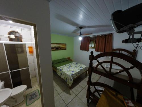 um pequeno quarto com uma cama e uma casa de banho em Pousada entre Paraísos em Angra dos Reis