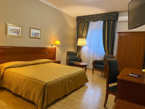 En eller flere senge i et værelse på Hotel Il Vigneto