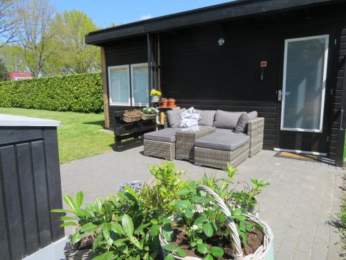 a patio with a couch and some plants at Vakantiewoning De Klaproos in Boyl
