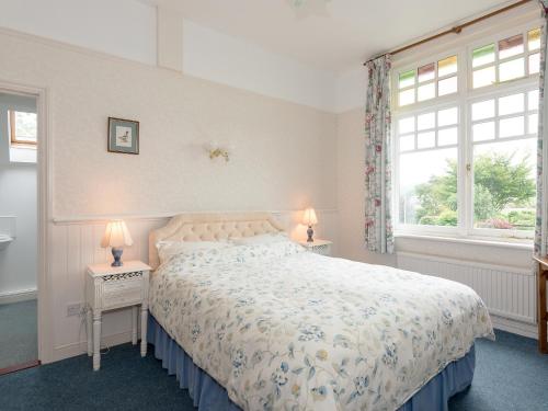a bedroom with a bed and two night stands with lamps at Neuadd Las in Tregaron