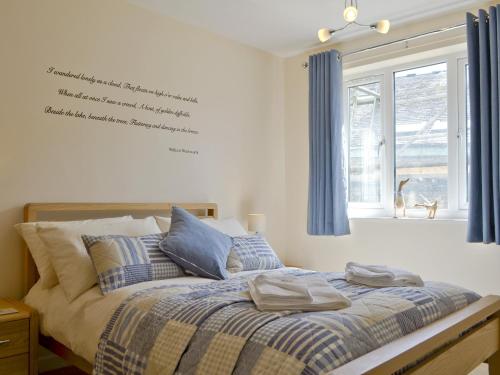 ボウネス・オン・ウィンダミアにあるLow Riggのベッドルーム1室(青いカーテン、窓付)