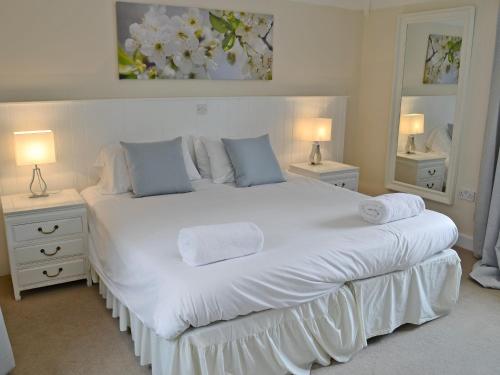 a bedroom with a large white bed with two lamps at Pond-b6844 in Sedghill