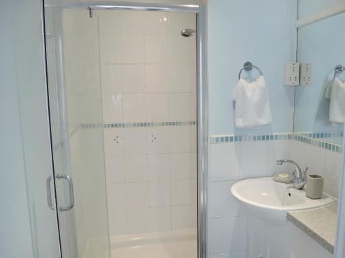 biała łazienka z prysznicem i umywalką w obiekcie Pond-b6844 w mieście Sedghill