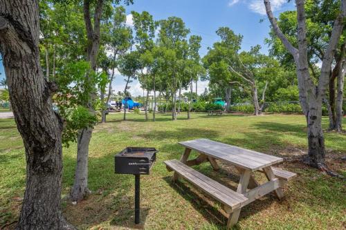 a picnic table and a trash can next to a tree at Islamorada Paradise Overlooking the Fabulous Florida Bay. in Tavernier