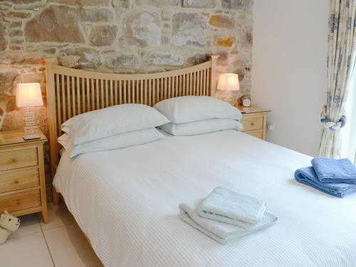 Un dormitorio con una cama blanca con toallas. en Cruary, en Applecross