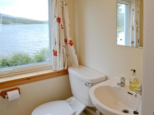 a bathroom with a toilet and a sink and a window at Cruary in Applecross