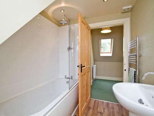a bathroom with a shower and a tub and a sink at The Hayloft - SNNL in Carnwath