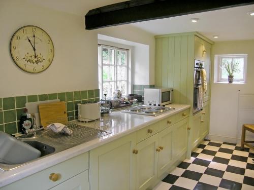 uma cozinha com um grande relógio na parede em Mill Cottage em Rievaulx