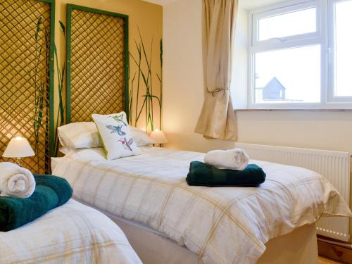two beds with towels on them in a bedroom at Reed Lodge in Littleport
