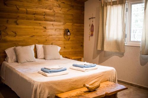 um quarto com uma cama com toalhas em Posada Los Cipreses em São Rafael