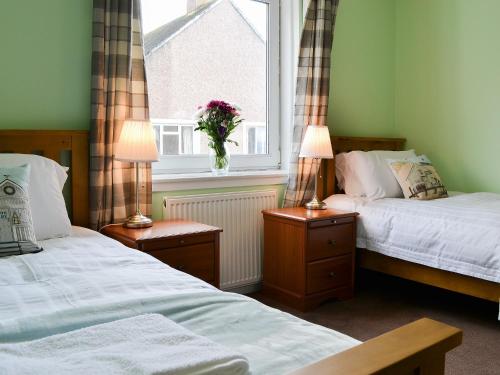 オーバンにあるHarbour Viewの窓とランプ2つが備わるドミトリールームのベッド2台分です。