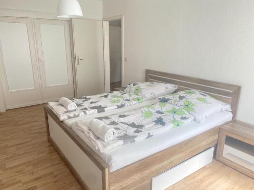 a bedroom with a large bed with white sheets at Zentrale 2-Zimmer Wohnung in Altstadt & Bahnhofsnähe ( überdachte Gartenterasse ) in Lübeck