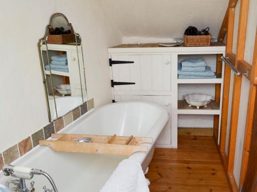 a bath tub in a bathroom with a mirror at Om Shanti - 28602 in Tipton Saint John