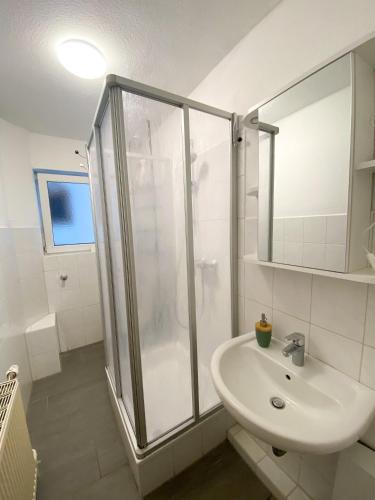 a white bathroom with a shower and a sink at Zentrale 2-Zimmer Wohnung in Altstadt & Bahnhofsnähe ( überdachte Gartenterasse ) in Lübeck
