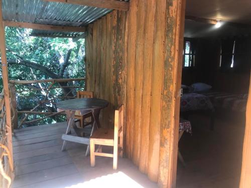 una mesa y sillas en el porche de una cabaña en Del Lago Hotel, en San Marcos La Laguna