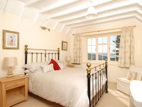 a bedroom with a bed and a window at Bishops View in Polzeath