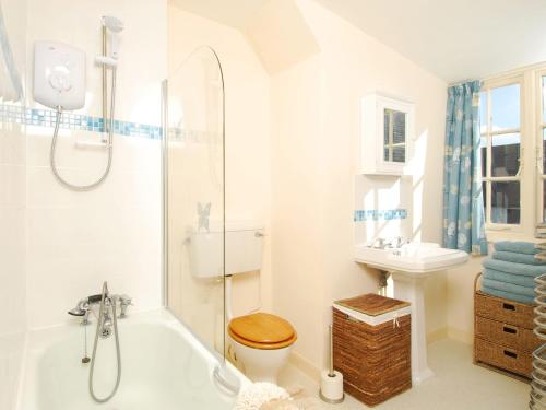 a bathroom with a tub and a toilet and a sink at Bishops View in Polzeath