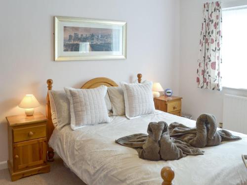 two stuffed animals are sitting on a bed at Dart Corner in Bovey Tracey