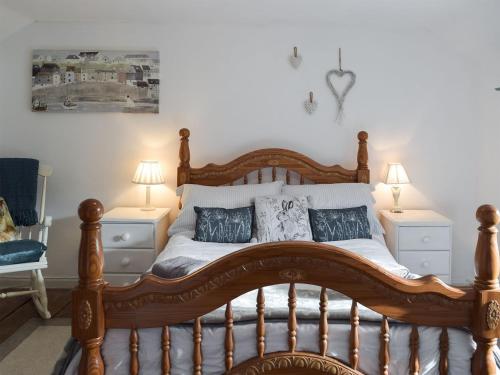 Freystrop的住宿－Woodlands Cottage，一间卧室配有一张带枕头的大型木制床。