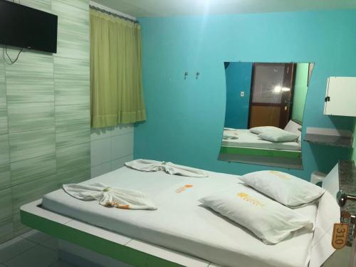 Habitación hospitalaria con 2 camas y espejo en Hotel Lotus, en Salvador