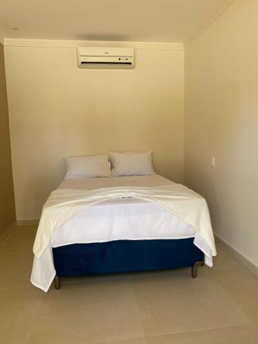 a bedroom with a large bed with white sheets and pillows at Pousada Vibe Guajiru in Trairi