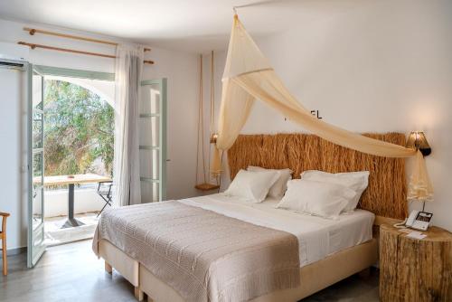 a bedroom with a large bed with a canopy at Parosland Hotel in Aliki
