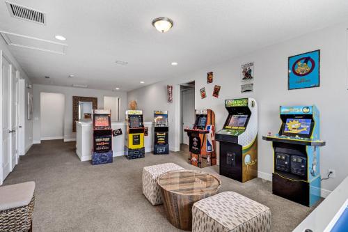 uma sala com vários jogos de arcada e uma mesa em Spacious 8 BDR Family Home with Arcades and Free Pool Heat em Orlando