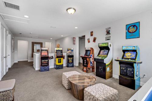 a room with several arcade games and a table at Spacious 8 BDR Family Home with Arcades and Free Pool Heat in Orlando