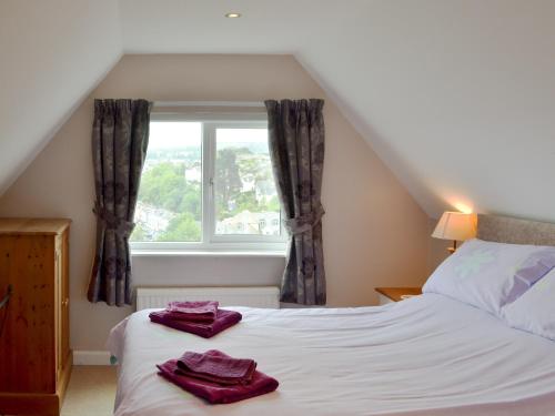 ein Schlafzimmer mit einem Bett mit lila Handtüchern darauf in der Unterkunft Samphire in Brixham