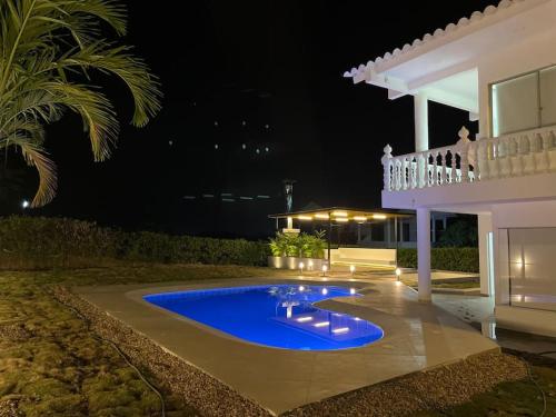 une villa avec une piscine la nuit dans l'établissement Casa Campestre Girardot, à Girardot