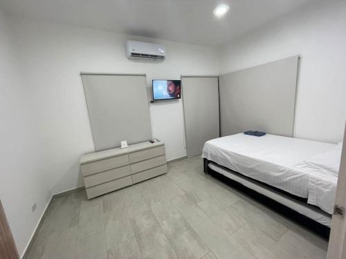 a bedroom with a bed and a tv on the wall at Casa Campestre Girardot in Girardot