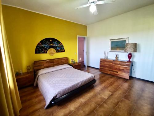 a bedroom with a bed and a yellow wall at Casa Angelica (Pizzo, Tropea, Lamezia) in Maida