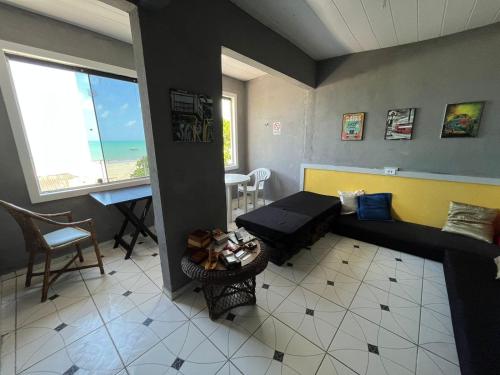 a living room with a couch and a view of the ocean at Hostel da Praia Maragogi in Maragogi