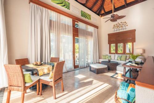a dining room with a table and chairs and a living room at Charming villa At Cap Cana in Punta Cana