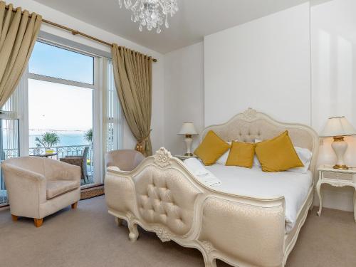 a bedroom with a white bed and a large window at The Downs in Torquay