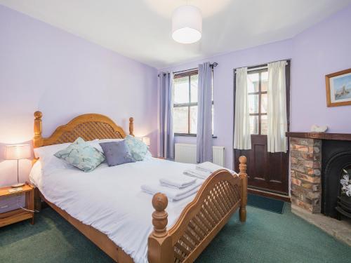 a bedroom with a wooden bed and a fireplace at Apple Tree Cottage in Scalby