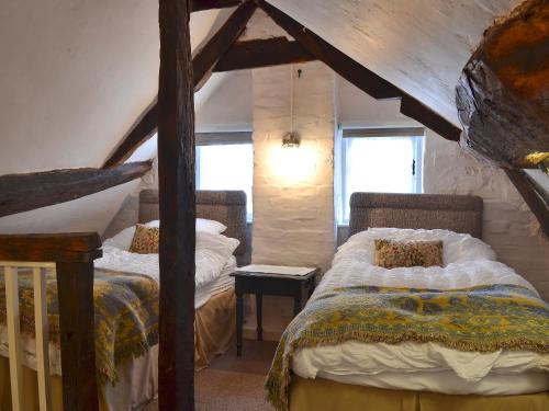 ヘイルにあるChilde Of Hale Cottage - 27896のベッドルーム(ベッド2台付)が備わる屋根裏部屋です。