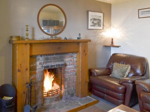 a living room with a fireplace with a mirror at 3 Breckery in Staffin